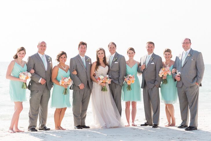 Her bridesmaids were ready for the beach (and Florida’s heat) in short mint Jim Hjelm dresses. Each had a chiffon skirt that flowed from the empire waist and ruching along its bodice. The women paired their looks with the same gold necklaces and updo hairstyles. To match them, the groomsmen wore gray suits from Men’s Wearhouse with mint ties.