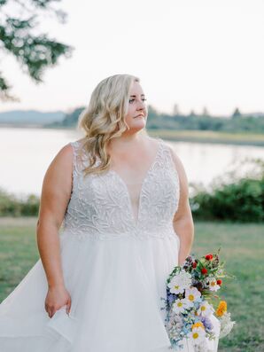 Bride in Deep V-Neckline Wedding Dress Holding Bouquet of Wildflowers