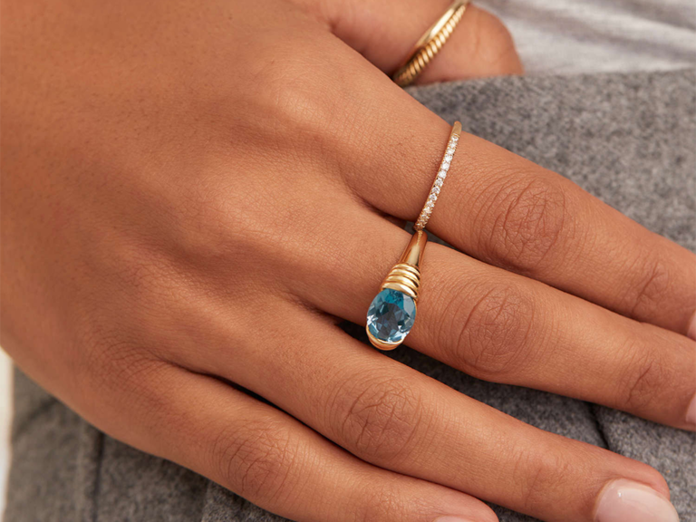 Blue topaz stone ring set in thick gold band