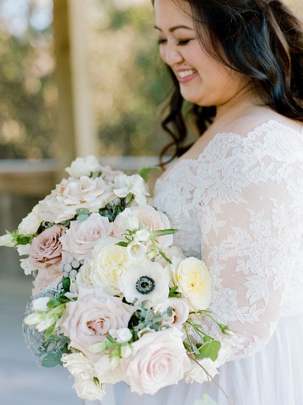 Bride holding bouquet with white, pink and gray flowers