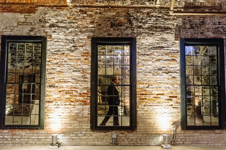 The reception took place inside the Mount Washington Mill Dye House in Baltimore, Maryland, where exposed brick walls and black windows gave the venue a rustic edge—perfect for a rustic-meets-elegance wedding.