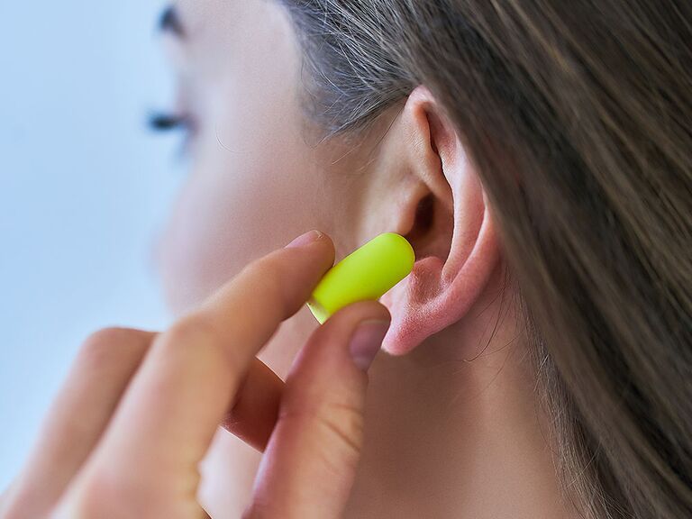 woman inserting ear plug
