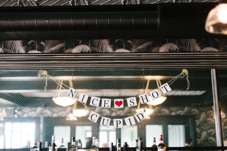 Valentine's Day-themed details included heart-shaped confetti, arrow coasters and a paper banner that read "Nice Shot Cupid"—a cute touch that the couple found on Etsy.com