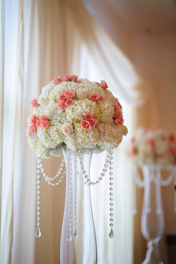 The couple decorated their ceremony with two arrangements of pink roses, white roses and white hydrangeas atop tall clear glass vases.