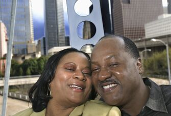 A couple on a ferris wheel with the Houston skyline behind them.