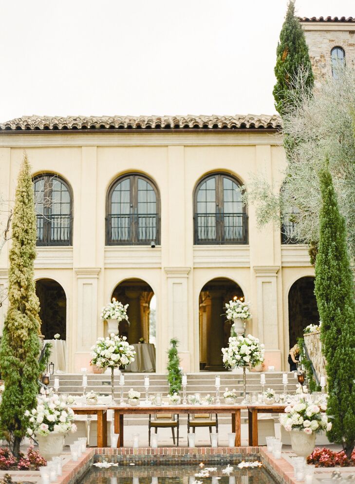 Arrangements of ivory and blush colored roses and hydrangeas lined the reception tables, surrounded by white pillar candles in clear glass candlesticks.