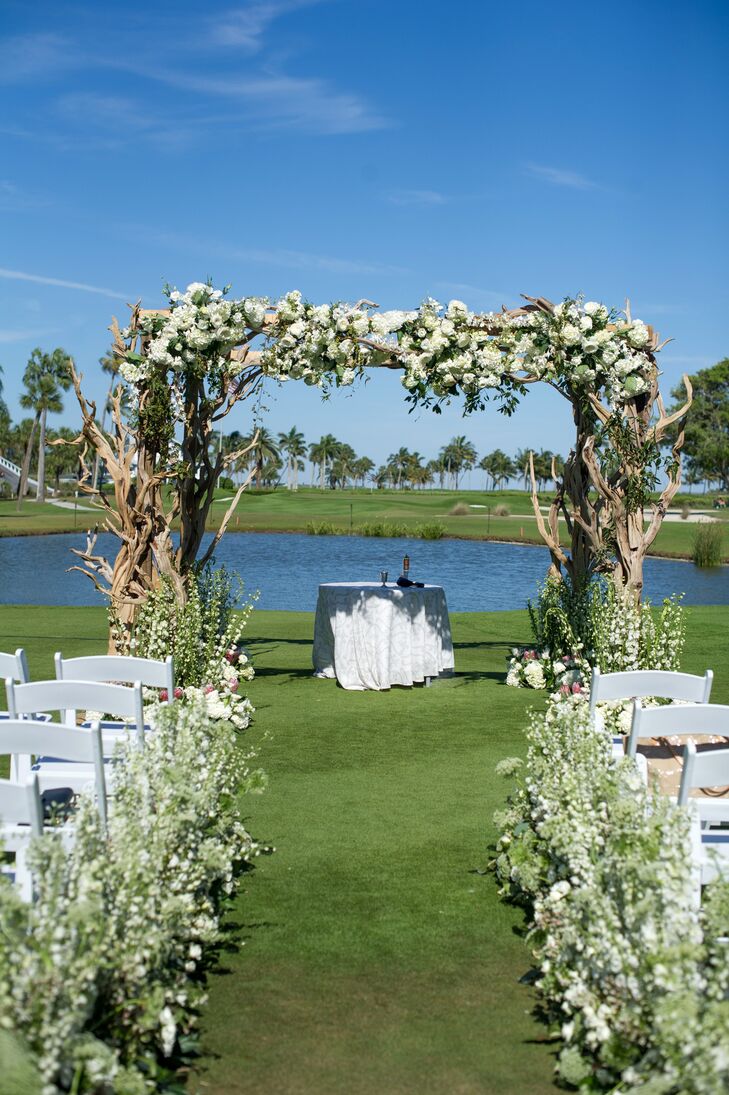 Taking advantage of the sunshine and waterfront setting, Emily and Jason hosted their ceremony outdoors overlooking swaying palm trees and a quaint pond. “Our florist lined the aisle with flowers that looked like they were growing from the grass—this was so pretty and gave the ceremony location a whimsical, garden vibe,” Emily says. The wedding arch was the ceremony’s showstopper, with fluffy hydrangeas and textured greenery adorning a beachy driftwood structure.