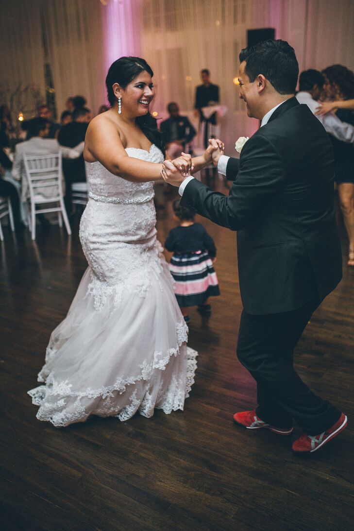 The couple, who met while salsa dancing, performed a bachata number for their first dance. The bride wore salsa shoes and the groom changed into comfortable red sneakers for their reception at Belle Mer in Newport, Rhode Island.