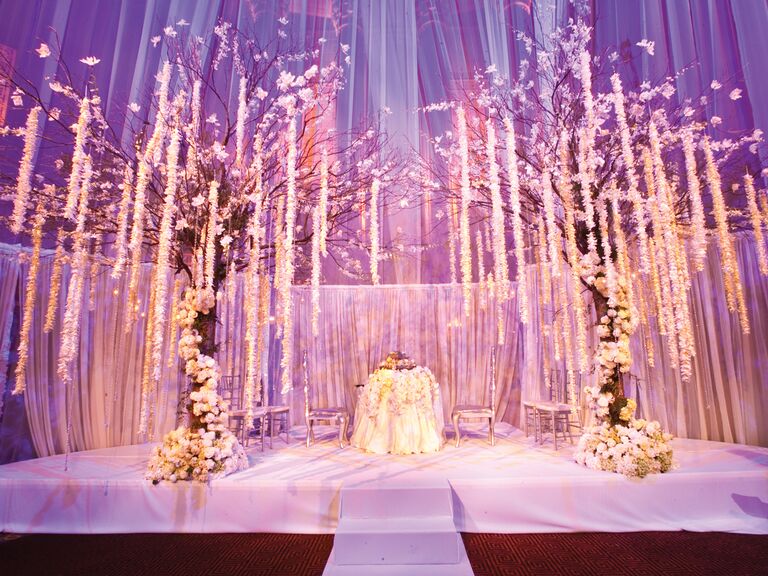 Indoor wedding ceremony with purple uplighting and flower garlands