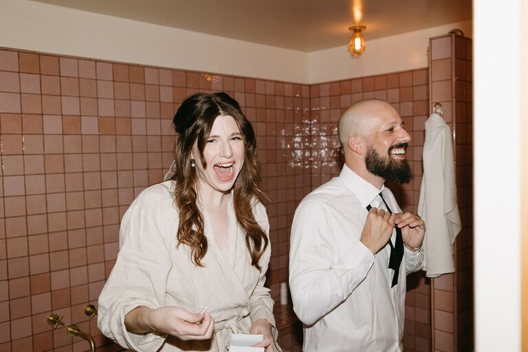 Couple gets ready for their wedding day together. 