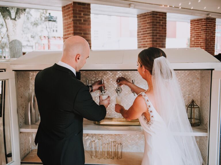 bride and groom pouring beer from tap on mobile bar truck 