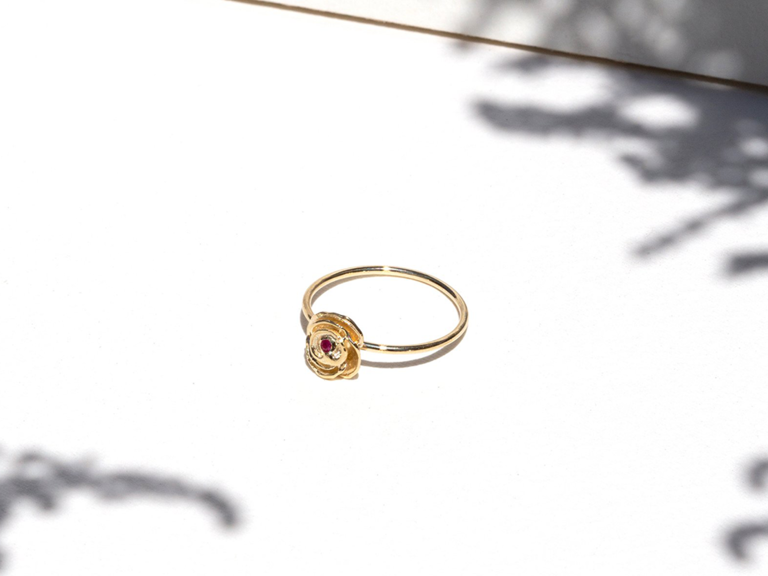 Ruby round center stone with gold floral setting on thin gold band