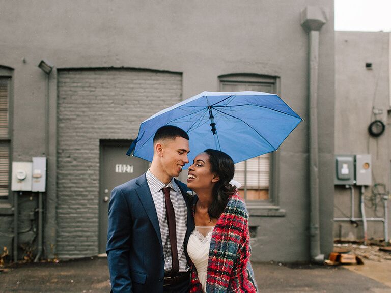 couple posing under umbrella for engagement photo