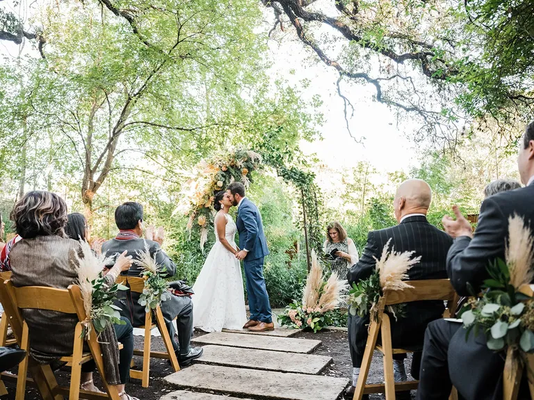 Couple kissing at the altar in outdoor ceremony space at The Sanctuary Event Space wedding venue in Austin, Texas