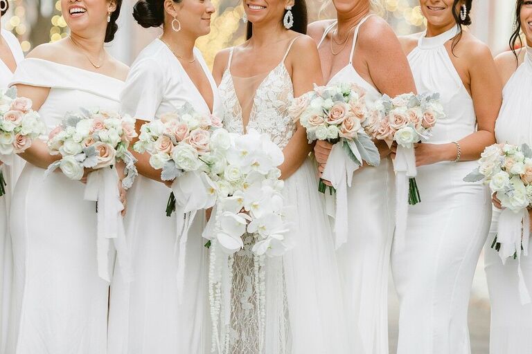 Bridal party in white dresses with white floral bouquets
