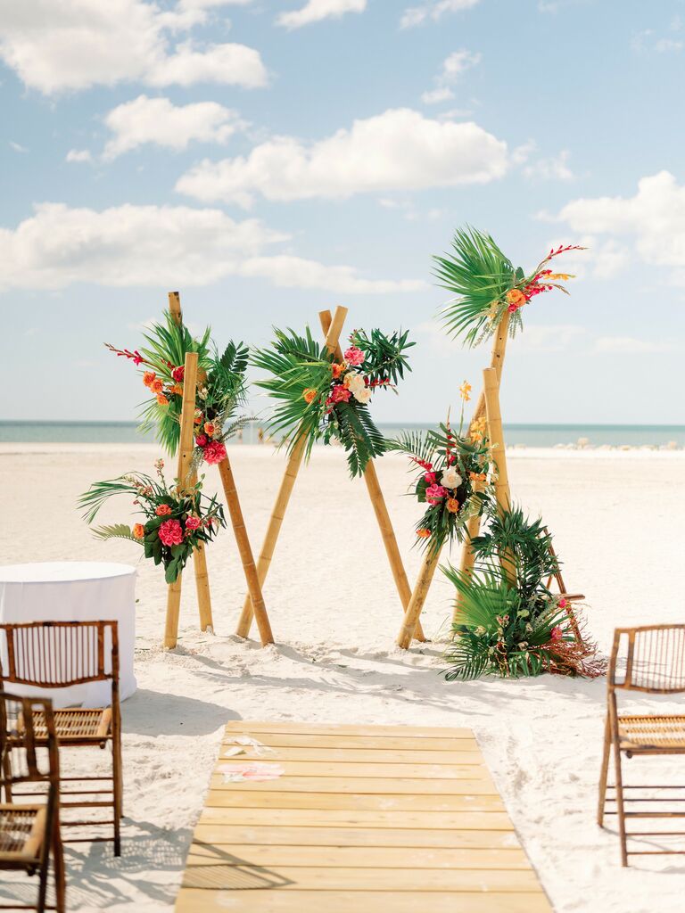 beach wedding arch alternative with bamboo poles and tropical flowers