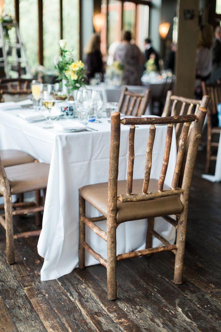 "Because the River Cafe is very rustic all on its own, it was a perfect location to have a wedding with a vintage feel," Jennifer says. Wooden chairs on a distressed wooden floor enhanced the natural coziness of the cafe. White table linens and canary yellow flowers lightened the ambience.