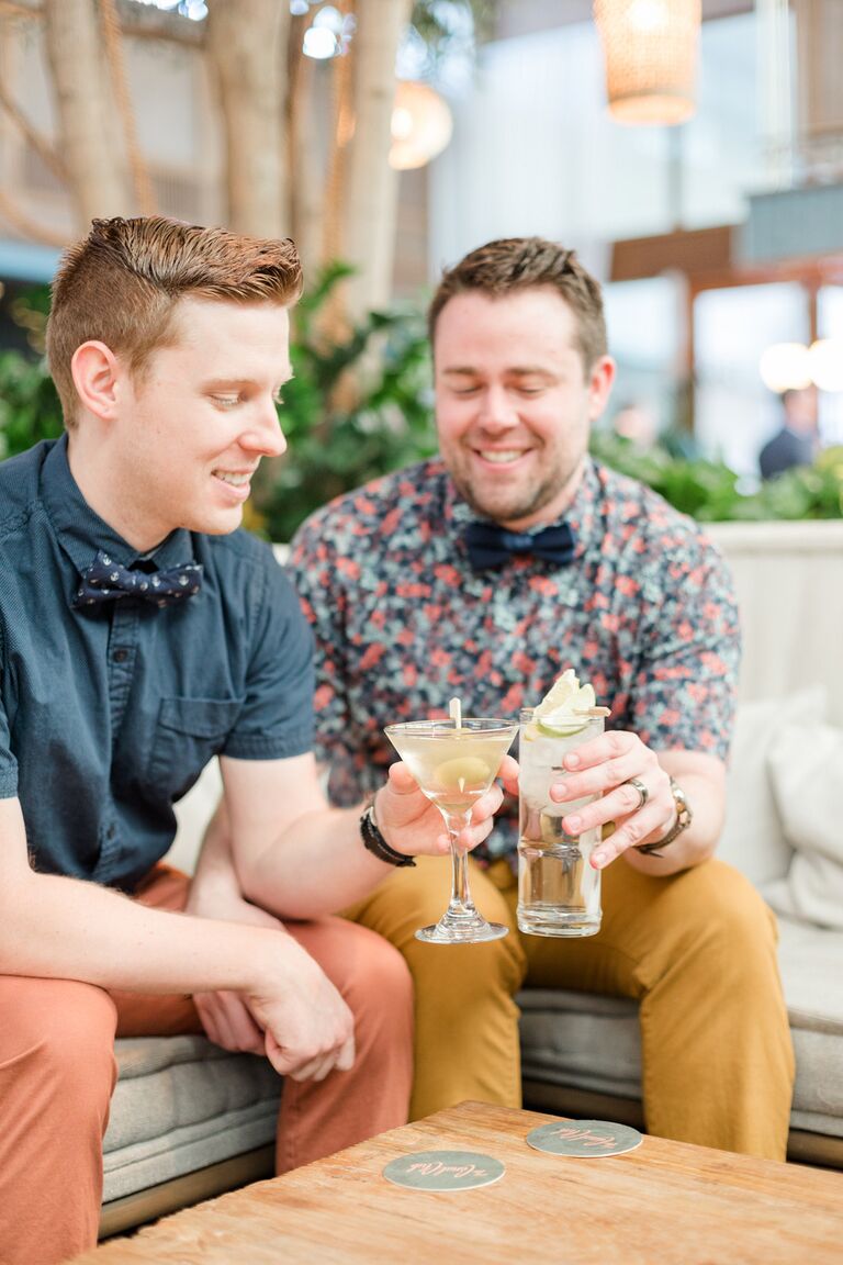 Grooms toast with craft cocktails during engagement photo shoot