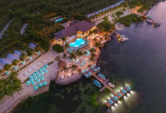 Bungalows Key Largo aerial resort view blue umbrellas and lit pool at sunset