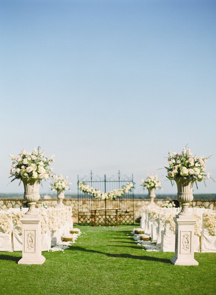 Ornate stone pillars stood at the entrance to the ceremony. The urns were filled with ivory and blush hydrangeas and roses for a traditional, romantic look.