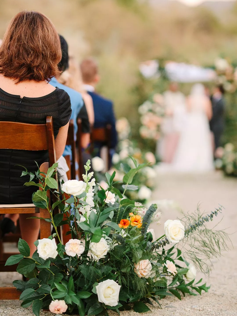 A gorgeous floral arrangement of white roses and vibrant greenery.
