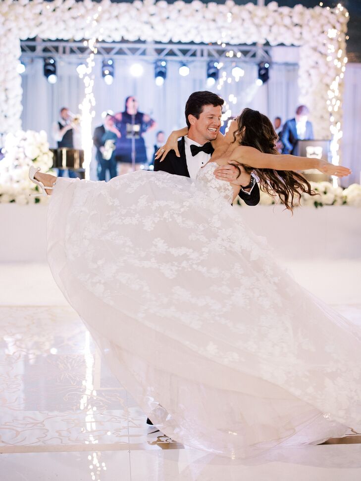 Groom Spins Bride in Ballgown Around on a White Dance Floor