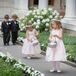 The couple's two flower girls wore light pink and ivory satin dresses by US Angels. The girls carried baskets of pink rose petals which they scattered across the ceremony aisle.