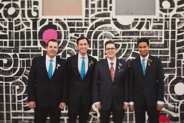 Matt wore a charcoal gray suit designed by Canali with an orange and purple paisley tie, and had a green succulent wrapped in yarn pinned to his jacket lapel. He stood next to his groomsmen wearing the same suit but with bright blue ties instead, and they also wore succulents wrapped with yarn pinned to their jacket lapels.