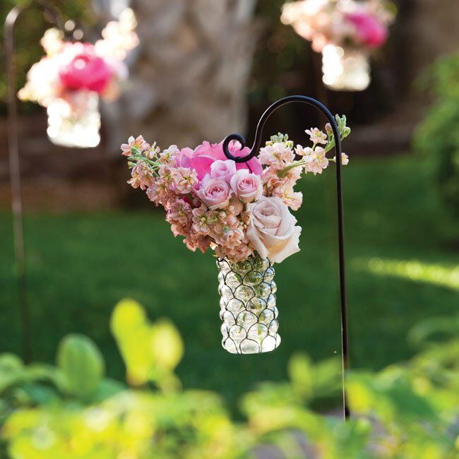 The path to the ceremony site was lined with vases of pink flowers hanging from shepherd's hooks.