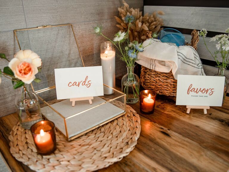 wedding gift table with gold glass card box, votive candles and wedding favors in wicker basket