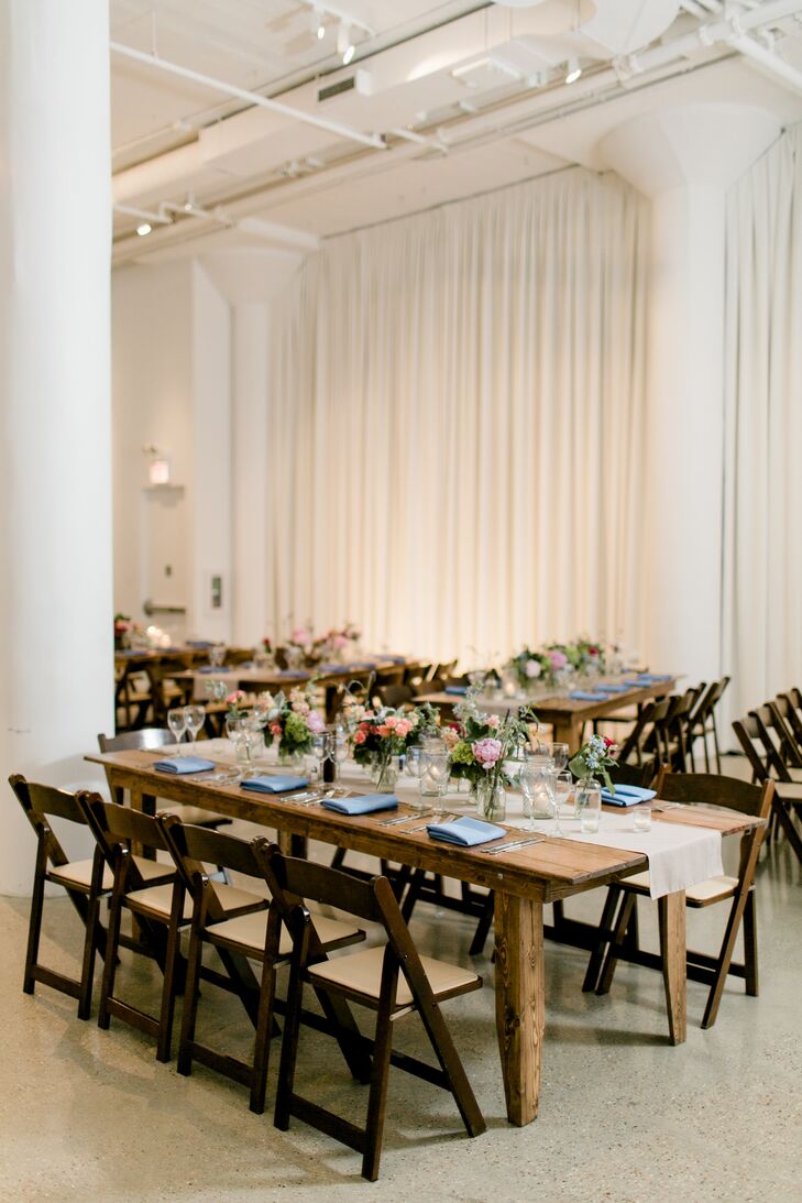 Wooden tables, taupe runners (rather than linens), candles and local and naturally sourced floral arrangements created a sophisticated yet rustic vibe at Chez in Chicago, Illinois. Three types of centerpieces provided some variety: a single large arrangement in a wooden box flanked by pillar candles, a branch surrounded by flower clusters in small vases and three smaller arrangements in glass mason jars with flower clusters in small vases. The tablescapes were further accented with tealights.
