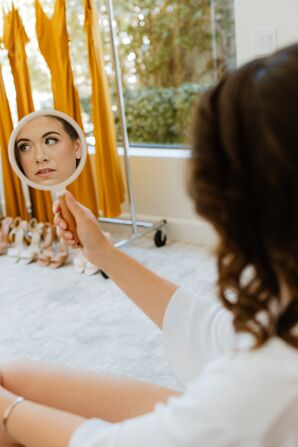 Bride Looking at Makeup in the Mirror While Getting Ready