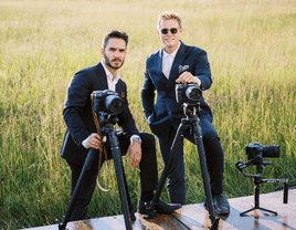 Two wedding photographers and videgraphers posing for a pitcture. 