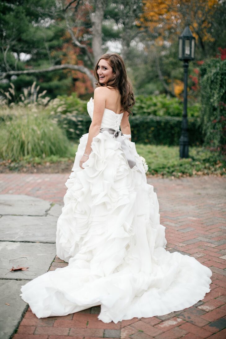 Joelle looked radiant in a Maggie Sottero ball gown, which she bought at Bijou Bridal. The dress features a voluminous, ruffled train. Joelle also wore a satin gray sash.
