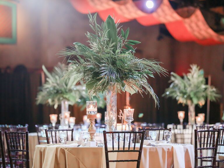 simple wedding centerpiece idea with assorted greenery in tall glass vase