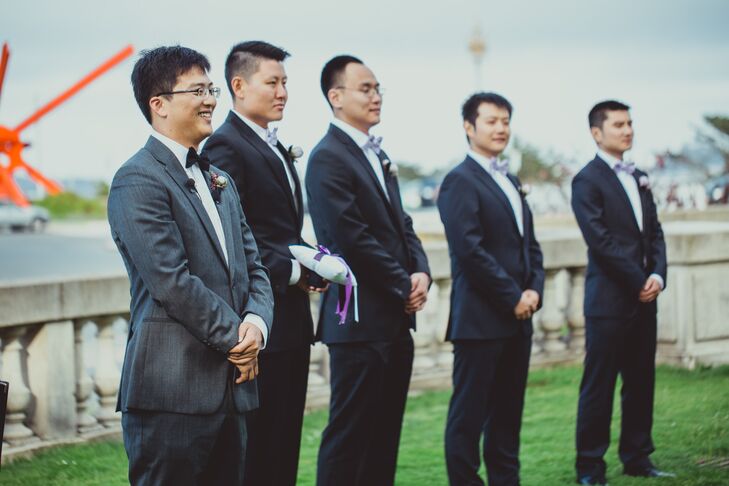 Chengyuan stood at the front of the ceremonial space on the lawn at Legion of Honor in San Francisco, California, surrounded by breathtaking views of the Golden Gate Bridge. He wore a classic black bow tie with his charcoal suit, while his groomsmen stood next to him wearing black suits with purple bow ties.