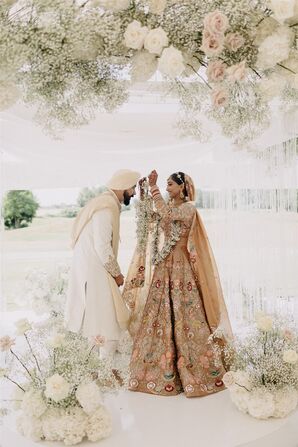 Sikh Bride Putting Garland Around Groom's Neck at Guru Granth Sahib Altar, Hanging Flowers, Arrangements, Traditional Outfits