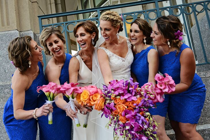 When it came to her bridesmaids’ attire, Ashley decided to have the girls don matching styles to create a cohesive look. She selected a cocktail-length dress with a flattering one-shoulder neckline, lace overlay and vibrant blue fabric, which made their bright pink and orange bouquets really pop.