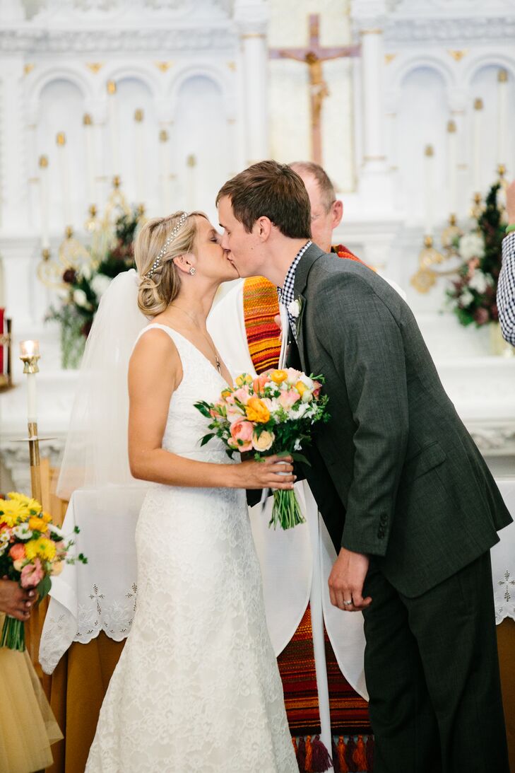 For their traditional Catholic ceremony, Katie wore a modified A-line wedding dress. She loved how simple and chic it was with the lace overlay and V-neck. She completed her look with an elbow-length tulle veil in her low updo. Afterward, she changed into a strapless white dress from 6PM.