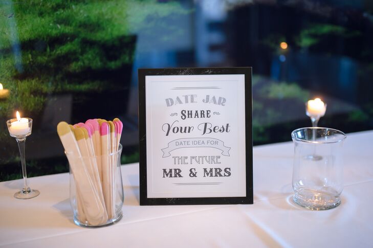 In lieu of a traditional guest book, the couple asked friends and family to write date night ideas on pink and gold accented wooden sticks.