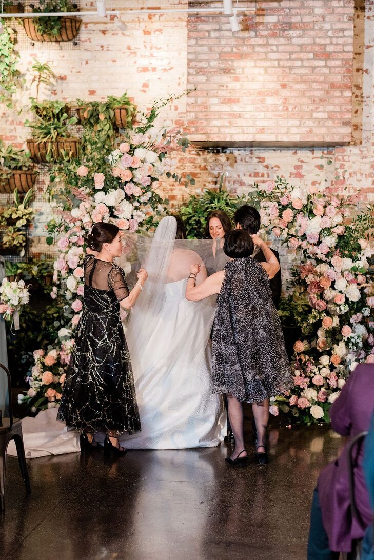 Bride and Grooms' Mothers Performing a Veil Ceremony at the Floral Altar