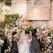 Bride and Grooms' Mothers Performing a Veil Ceremony at the Floral Altar