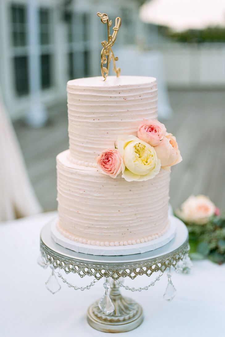 Katie and Nick’s wedding cake featured two blush tiers to complement Katie’s wedding dress with fresh ivory and blush garden rose accents and a gold, twisted metal ‘K’ cake topper.