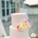 Katie and Nick’s wedding cake featured two blush tiers to complement Katie’s wedding dress with fresh ivory and blush garden rose accents and a gold, twisted metal ‘K’ cake topper.
