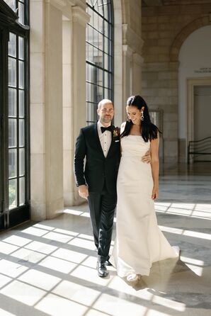 Groom in Black Tuxedo and Bride in Column Dress Walk in Museum