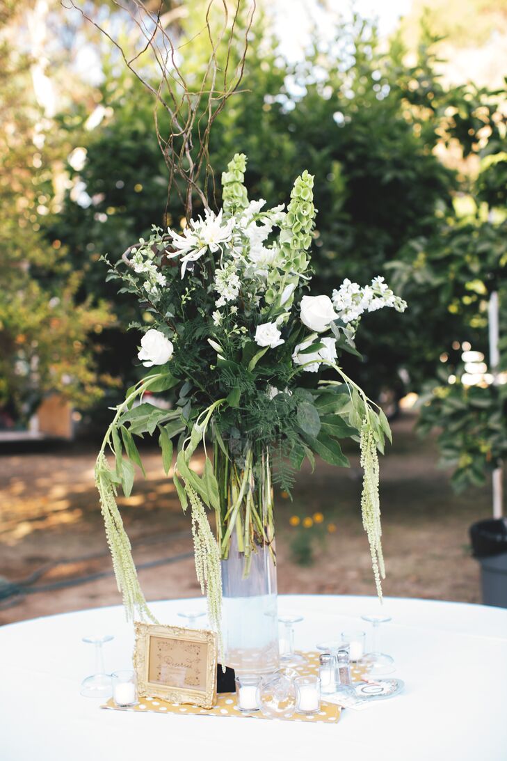 Lush arrangements or ivory roses and chrysanthemums mixed with bells of Ireland and white amaranths decorated dining tables at the reception.