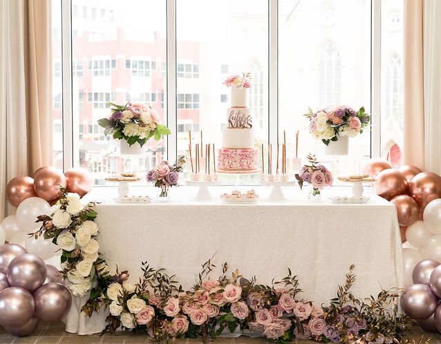 bridal shower dessert table surrounded by pink iridescent balloons