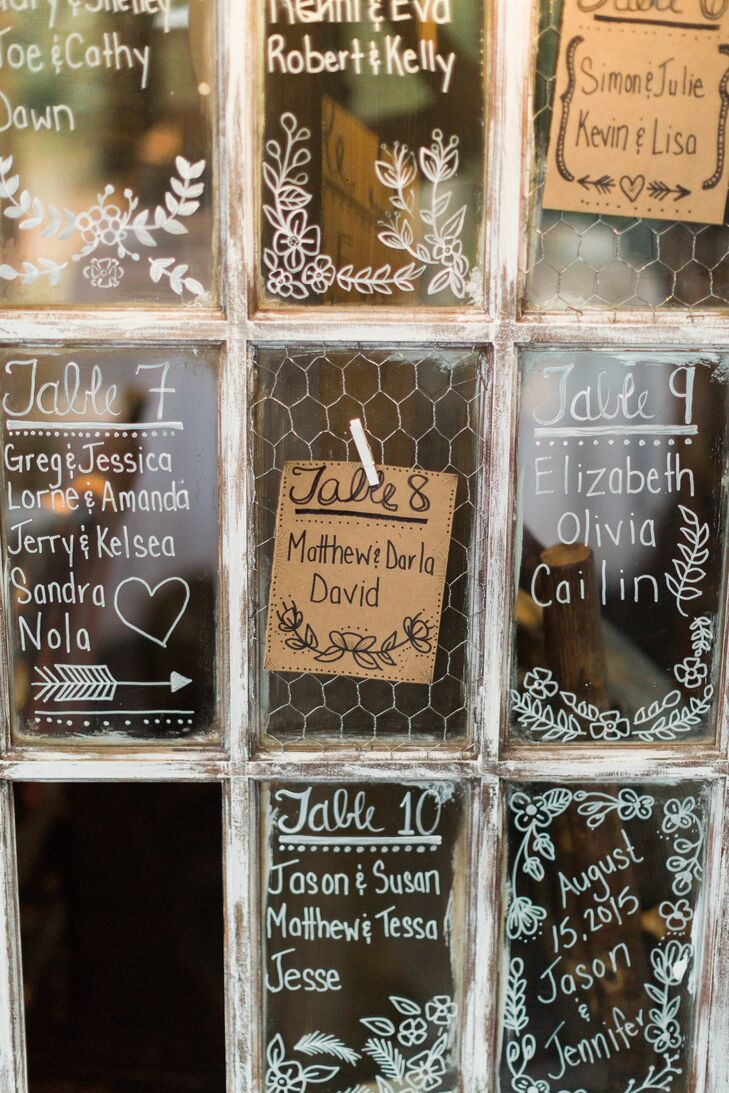 Jennifer and Jason arranged their seating chart on a vintage door with glass panels and chicken wire. They painted names, laurels and arrows onto the glass and pinned rustic brown-paper tags to the chicken wire so guests could find their seat.
