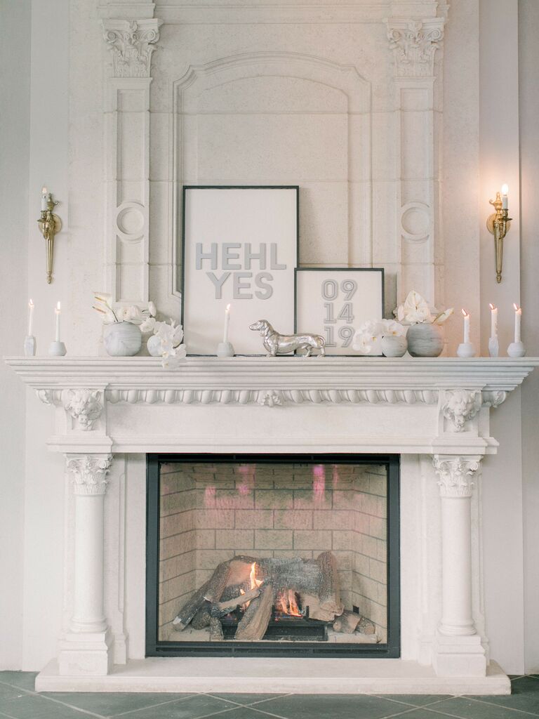 modern wedding fireplace decor with monochromatic white and silver flowers, candles and signs