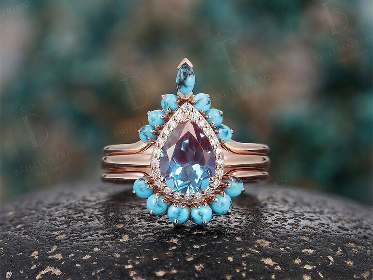 Teardrop alexandrite halo ring with turquoise stones bordering on gold band